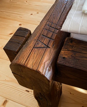 Detail pohledu na rám postele, který je vytvořen ze starých trámů